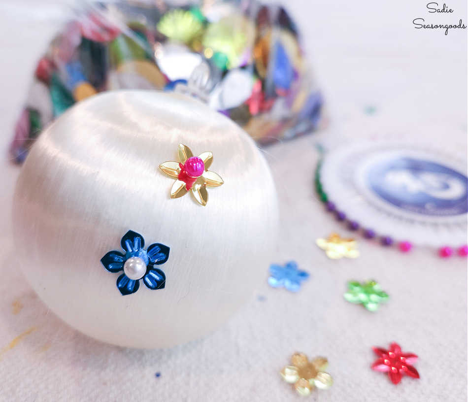 decorating a satin christmas ornament with sequins