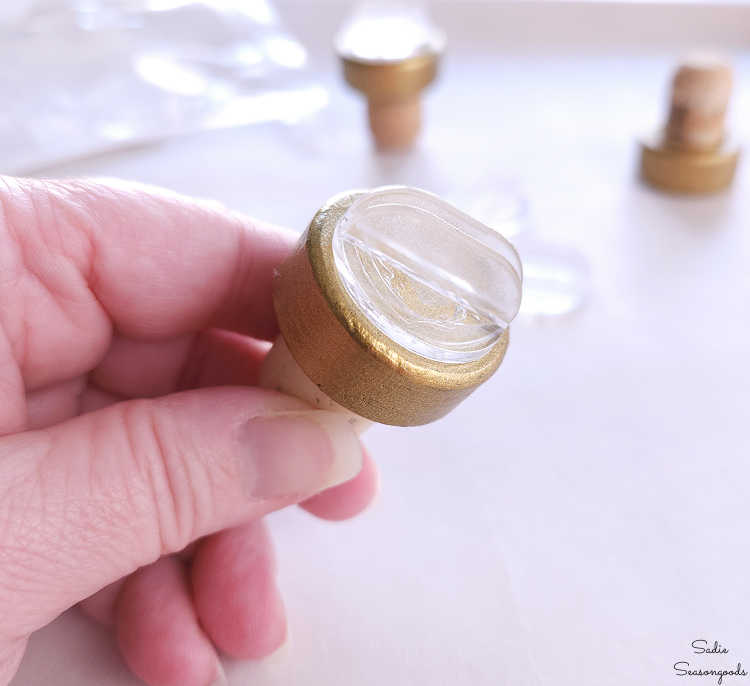 gluing a place card holder on top of a bar top cork