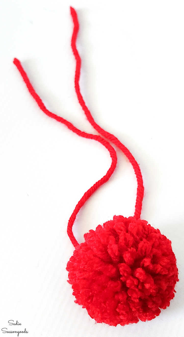red pompom with long tails for tying