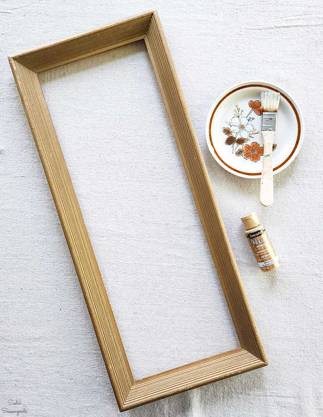 dry brushing gold paint on a vintage frame